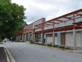 Empty street view of a Jo-Ann fabric and craft store with red pergola and overcast sky