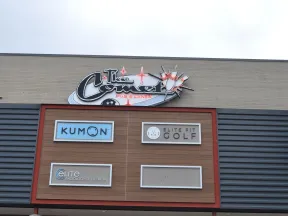 Storefront signs for Kumon, Elite Fit Golf, Elite Radiology of Georgia, and The Comet Pub & Lanes on a commercial building.