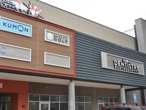 Shopping center facade featuring Kumon, Elite Fit Golf, Elite Radiology of Georgia, and Dentistry & Orthodontics signs.