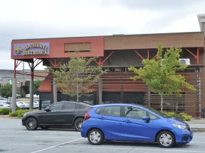 Louisiana Bistreaux restaurant exterior with parked cars in front on a cloudy day.