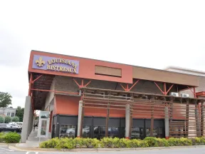 Exterior view of Louisiana Bistreaux restaurant with red and brown facade and wooden pergola structure.