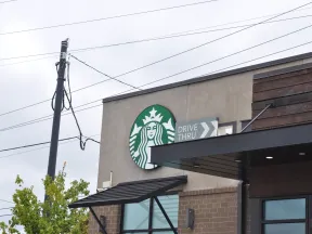 Starbucks coffee shop exterior with drive-thru sign on a cloudy day