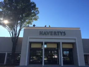 Havertys furniture store exterior with clear blue sky and large tree on the left side.