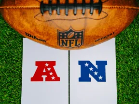 NFL logo with a football over letters A and N on green grass background.