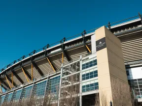 Exterior view of a modern sports stadium under a clear blue sky.