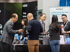 People interacting at a tech booth displaying Sparkle Intel Arc Pro B60 graphics cards at a technology exhibition.