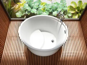 White round bathtub on wooden slat floor with large window and green garden outside
