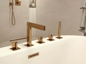 Modern bathroom with white bathtub featuring sleek bronze faucet and matching shower fixtures
