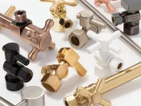 Assorted metal plumbing valves and fittings in gold, silver, black, and copper on white background