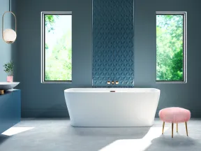 Modern bathroom with freestanding white bathtub, blue walls, two windows, round mirror, and pink stool.