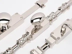 Close-up of polished silver door latches with round and oval knobs on a white background.