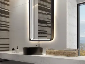 Modern bathroom with illuminated rectangular mirror, black sink, marble countertop, and wicker basket with towels.