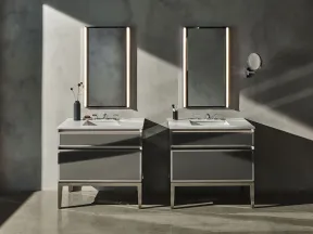 Modern double bathroom vanity with illuminated mirrors and minimalist decor against a concrete wall.