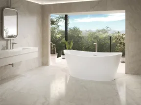 Modern bathroom with a freestanding white bathtub, large window showcasing greenery, and sleek sink with mirror.