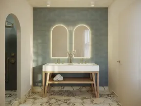 Modern bathroom with double sinks, backlit arched mirrors, blue tiled wall, wooden vanity, and marble floor.