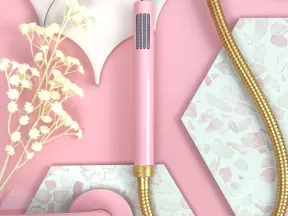 Pink and gold shower head with floral decor on pink and terrazzo tile background