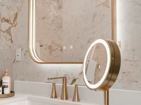 Modern bathroom sink with gold fixtures, illuminated round vanity mirror, and marble walls for a luxurious look.
