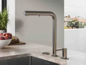 Modern stainless steel kitchen faucet with matte countertop and black sink under natural daylight