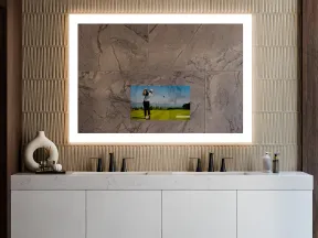 Modern bathroom vanity with double sinks, backlit mirror, textured wall, and decorative items on counter