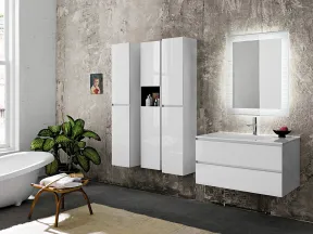 Modern bathroom with freestanding tub, floating white cabinets, illuminated mirror, and a green plant by textured wall.