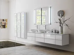 Modern bathroom with double vessel sinks, illuminated mirror, and sleek white floating vanity under window.