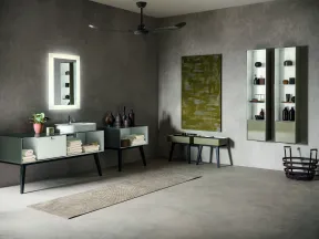 Modern gray bathroom with floating cabinets, illuminated mirror, wall art, and minimalist decor in soft lighting
