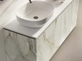 Modern bathroom vanity with white vessel sink, wall-mounted faucet, marble cabinet, and decorative vases.