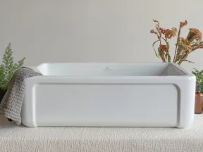 White rectangular ceramic sink on textured beige fabric with towel and dried floral decoration