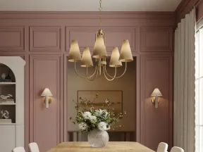 Modern dining room with wooden table, upholstered chairs, pink walls, abstract rug, and gold chandelier lighting.