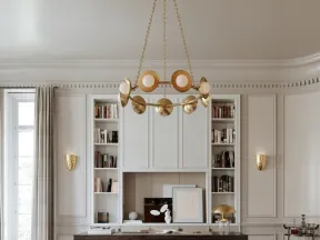 Modern living room with curved gray sofas, round stone coffee table, dark wood desk, and brass chandelier.