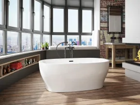 Modern bathroom with freestanding tub, large windows, city view, exposed brick wall, and wooden flooring.