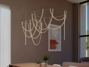Modern satin white suspension lights over a wooden dining table in a minimalist living space with artwork and natural light.