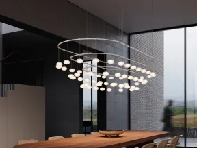 Modern dining room with a long wooden table, woven chairs, and circular globe pendant lighting.