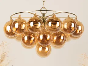 Modern chandelier with multiple amber glass globe bulbs hanging from a gold metal frame and chain.