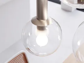 Modern pendant light with a clear glass globe and white bulb in a bright minimalist interior setting.