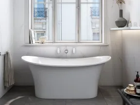 Modern white freestanding bathtub in a bright bathroom with large window and minimal decor
