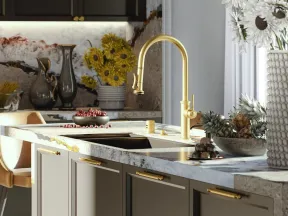 Modern kitchen with gold fixtures, marble countertops, sunflowers in vase, and crystal chandelier lighting.
