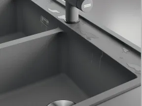 Modern matte gray double kitchen sink with water droplets and stainless steel drain and faucet.
