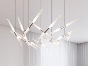 Modern geometric white chandelier hanging in a bright room with sheer curtains and potted plants.