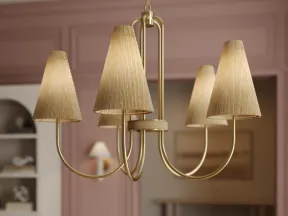 Elegant gold chandelier with fabric lampshades hanging over a floral centerpiece in a stylish pink-walled room