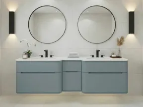 Modern bathroom with double vanity, round mirrors, black faucets, and minimalist blue cabinetry against white tiles.