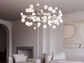 Modern living room with beige sofas, abstract wall art, marble coffee table, and a geometric chandelier.