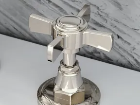 Close-up of a polished chrome faucet handle on a white marble countertop with gray veining background.