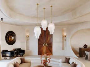 Modern living room with curved beige sofas, layered pendant lights, and sculptural wooden doors in a minimalist space.