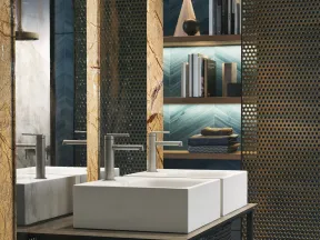 Modern bathroom with dual white rectangular sinks, metal mesh partitions, and backlit wooden shelves with decor.