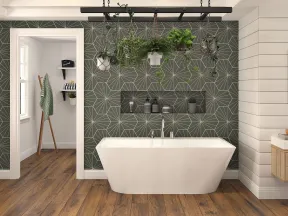 Modern bathroom with freestanding tub, geometric dark accent wall, hanging plants, and wooden flooring.