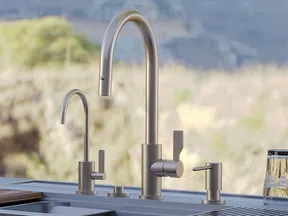 Modern outdoor kitchen sink setup with sleek stainless steel faucets and clear drinking glasses on countertop