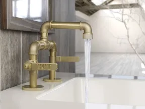 Vintage brass faucet with hot water running into a white sink in a modern rustic bathroom setting.
