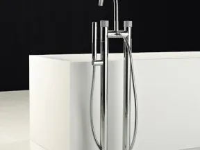 Modern chrome freestanding bathtub faucet with handheld shower against white tub and black background