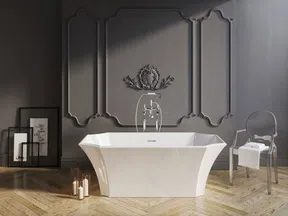 Modern white freestanding bathtub in a minimalist gray bathroom with decorative wall panel and transparent chair.
